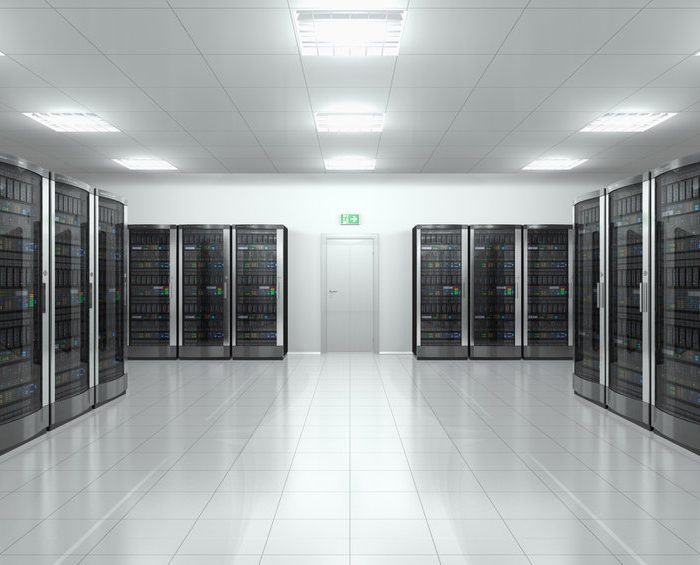 Rangs de serveurs informatiques alignés dans la salle blanche d'un data center moderne et éclairé.