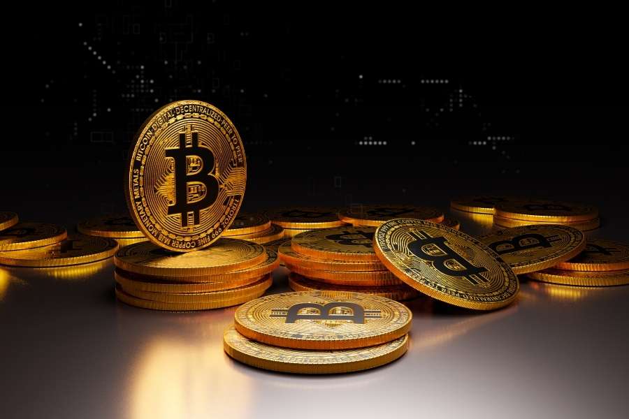 Piles de pièces dorées sur fond sombre pour illustrer le choix d'investir dans les altcoins.